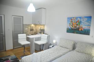 ein Wohnzimmer mit einem Sofa und einer Küche in der Unterkunft Dekart 2 Apartment in Niš