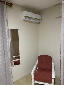 a red chair in a room with a air conditioner at Tenexia - La Gaulette Studio in La Gaulette