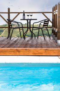 una mesa y sillas sentadas en una terraza de madera junto a una piscina en B&B Miellò, en Mango