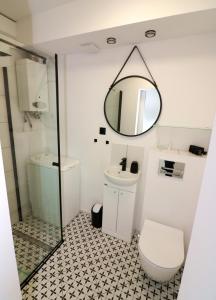 łazienka z toaletą i lustrem w obiekcie AAPARTAMENT w mieście Gdynia