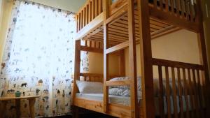 a bunk bed in a room with a curtain at Osotwa Maasai Hostel in Arusha