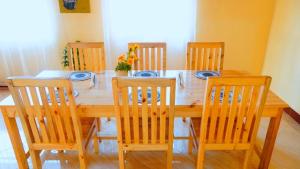 a wooden dining room table with six wooden chairs at Osotwa Maasai Hostel in Arusha