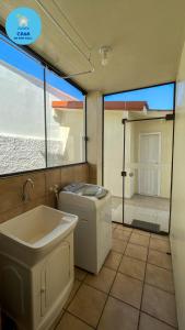 een badkamer met wastafel en wasmachine bij Casa do Mar Azul in Florianópolis