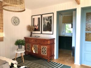 a living room with a wooden cabinet and a kitchen at Domek Pod Lasem 