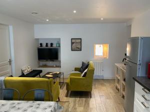 sala de estar con 2 sillas amarillas y cocina en Le ker Maclow, en Saint-Malo