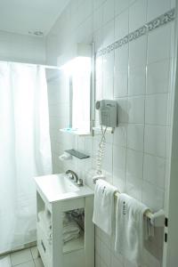 a white bathroom with a sink and a mirror at Green Hotel in Pilar