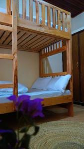 2 literas en una habitación con flores púrpuras en Osotwa Maasai Hostel, en Arusha