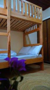 two bunk beds in a room with purple flowers at Osotwa Maasai Hostel in Arusha