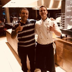 two men standing in a kitchen giving the thumbs up at La Maison Pondichéry in Puducherry