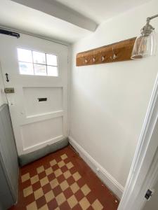 a room with a door and a checkered floor at Hurst cottage, a cosy 2 bed cottage in Dorset in Stalbridge
