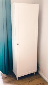 a white cabinet in the corner of a bedroom at Supreme Apartment in the City Center in Kraków