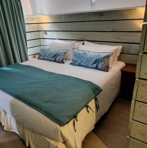 a bedroom with a large bed with two pillows at Apart Hotel Rapa Nui in Hanga Roa