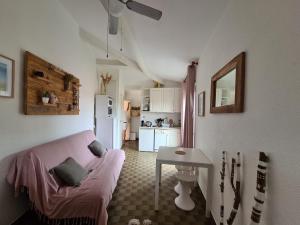 uma sala de estar com um sofá rosa e uma mesa em Le coeur des sables em Le Grau-dʼAgde