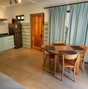 een keuken met een houten tafel en stoelen in een kamer bij Apart Hotel Rapa Nui in Hanga Roa