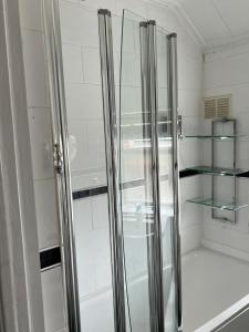 a walk in shower with glass doors in a bathroom at Luxury 3 Bedroom Apartment with Large Garden in Welling