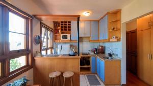 una pequeña cocina con armarios de madera y encimeras azules en Aconchegante Apto no Centro de Canela, en Canela
