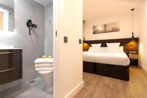 ein Hotelzimmer mit einem Bett und einem Bad in der Unterkunft Woohoo Rooms Hortaleza in Madrid