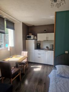 kuchnia i jadalnia ze stołem, stołem i krzesłami w obiekcie Studio La Cabane Centre Ville w mieście Le Bourg-dʼOisans