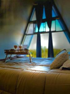 a bedroom with a bed with a table and a window at Cabaña Nórdica muy cómoda para unos días de relax in Villa Serrana