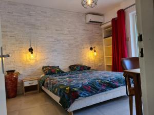 1 dormitorio con cama y pared de ladrillo en Le Bellissima, en Saint-Gilles-les-Bains