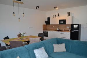 uma sala de estar com um sofá azul e uma cozinha em KVÍTKO em Frymburk