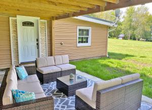 eine Terrasse mit 2 Sofas, einem Tisch und einer Tür in der Unterkunft Summer specials on the Saint Lawrence River in Ogdensburg