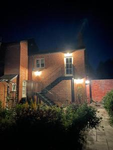 a brick house with lights on the side of it at Cockloft Romantic Countryside Hideaway in Bishops Cannings