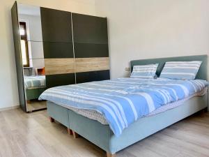 a bedroom with a blue bed and a mirror at Nice rooms in Beggen house - In Luxembourg city in Luxembourg