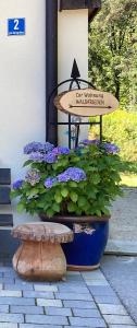 una gran olla azul con flores púrpuras y una señal en Haus Waldfrieden, en Bischofswiesen
