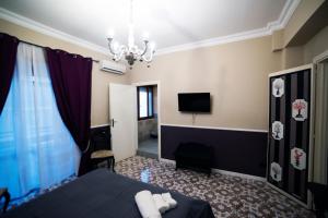pokój hotelowy z łóżkiem i telewizorem w obiekcie Barocco al centro w Katanii