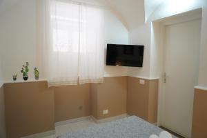 salon z telewizorem i oknem w obiekcie Sicily House Caronda Catania w Katanii