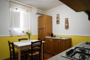 kuchnia ze stołem i krzesłami oraz kuchnia z żółtą w obiekcie Sicily House Caronda Catania w Katanii