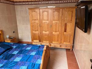 a bedroom with a bed and wooden cabinets at 2 Zimmer Wohnung Corniche Nador Sidi Ali- am Meer & Wifi in Nador