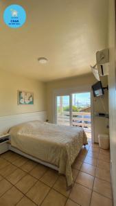 een slaapkamer met een bed en uitzicht op de oceaan bij Casa do Mar Azul in Florianópolis