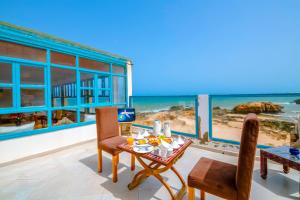 une salle à manger avec vue sur la plage dans l'établissement Riad Kafila, à Essaouira