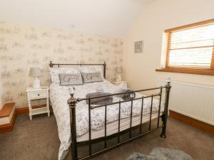 a bedroom with a bed and a window at Ash Farm Cottage in Holywell