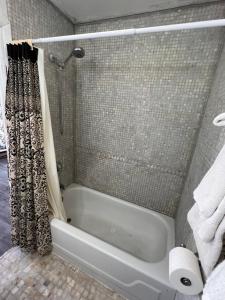 La salle de bains est pourvue d'une baignoire et d'une douche. dans l'établissement Liberty Motel, à Liberty