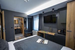 1 dormitorio con cama, lavabo y TV en 4 Évszak Erdeihotel**** - Mátrafüred en Mátrafüred