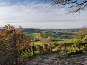 une clôture en bois sur le côté d'une colline dans l'établissement Agriturismo Azienda Agricola Mombisaggio, à Tortone