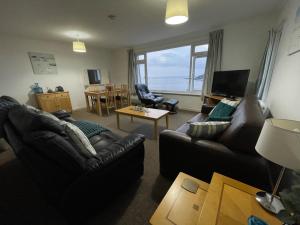 una sala de estar con sofás y vistas al océano. en Sea Spirit - Sweeping Sea Views first floor spacious modern apartment in Looe- with FREE parking!, en Looe