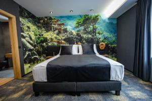 um quarto com uma cama grande e uma pintura na parede em 4 Évszak Erdeihotel**** - Mátrafüred em Mátrafüred