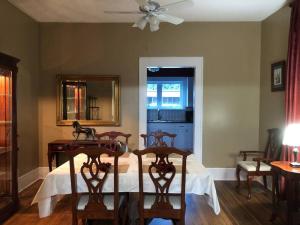 a bedroom with a bed with four chairs and a mirror at The Farmhouse at Wolfehaven in Asheville