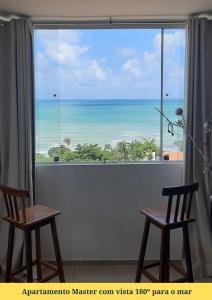 - une vue sur l'océan depuis une chambre avec 2 chaises dans l'établissement Apartamentos em Ponta Negra (Natal-RN) com vista para o mar, à Natal