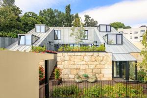 a house with a stone wall and windows at 108MM House in Porto