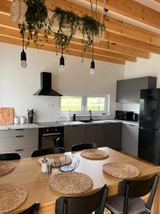 a kitchen with a wooden table with chairs and a kitchen with a counter at Holiday house DOMa Nová Lesná in Nová Lesná