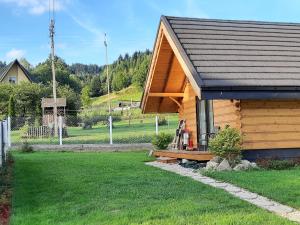 a log cabin with a porch in a yard at Domek na szlaku RIKARDO in Ponice