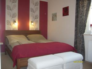 una camera con un letto con una parete rossa di Ferienwohnung Strandwiese a Graal-Müritz