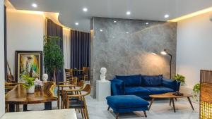 a living room with a blue couch and tables and chairs at Green Line Long Bien - Serviced Apartment - Ngoc Thuy - Hanoi in Hanoi