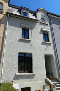 - un bâtiment blanc avec des fenêtres sur le côté dans l'établissement Nice rooms in Beggen house - In Luxembourg city, à Luxembourg