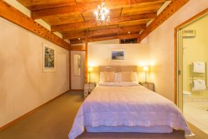 a bedroom with a bed and a chandelier at Kaimata lodge in Dunedin